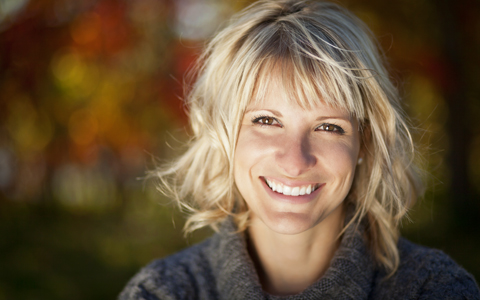 Smiling woman with porcelain dental veneers.