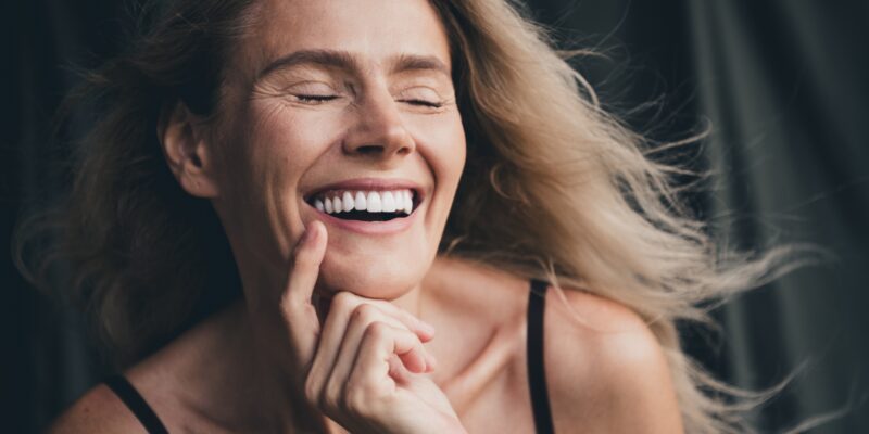 closeup of blonde woman smiling, showing natural looking veneers