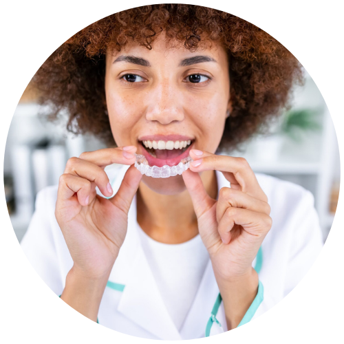 young woman holding up clear aligners from Rockwall cosmetic dentist