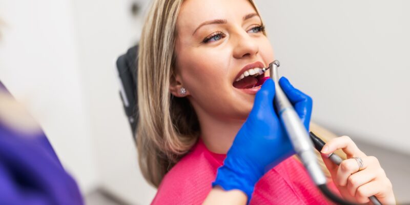dentist polishing a female patients bonded teeth